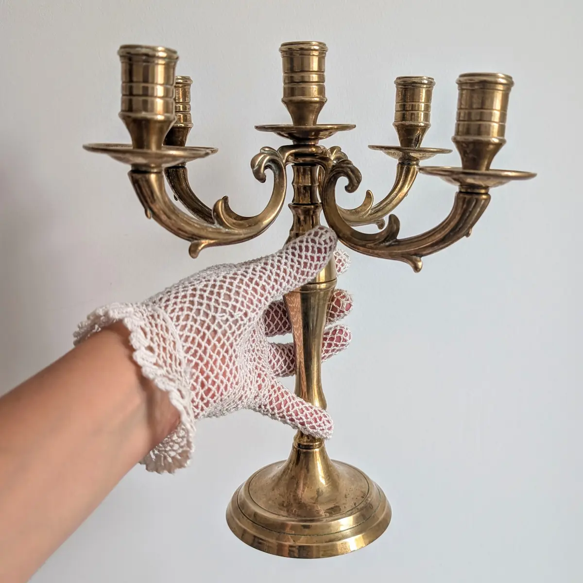 Chandelier en laiton à cinq feux tenu par le fût avec une main gantée