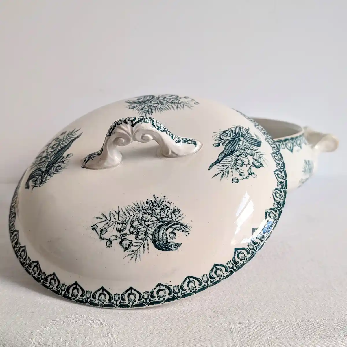 Couvercle bombé de soupière ancienne avec prise ajourée, motifs végétaux et oiseaux verts.