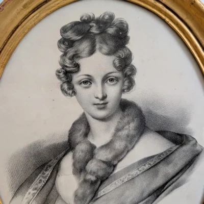 Gros plan du visage de Délie, de ses cheveux bouclés et de son étole de fourrure.