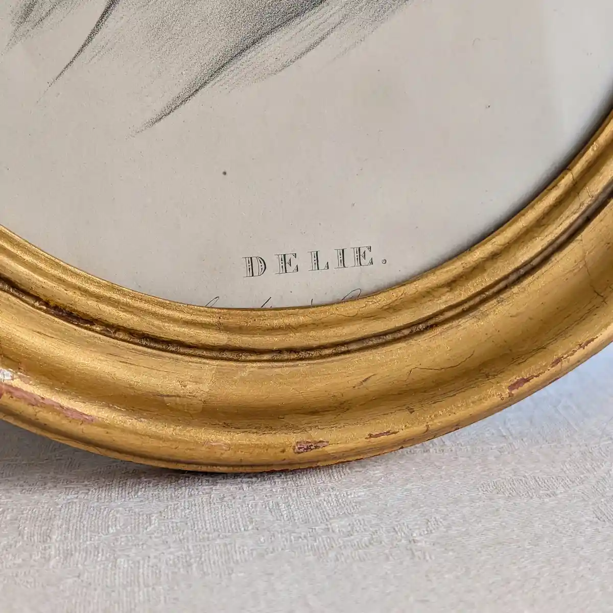 Inscription DELIE au bas du portrait et détails des craquelures et manques de dorure du cadre.