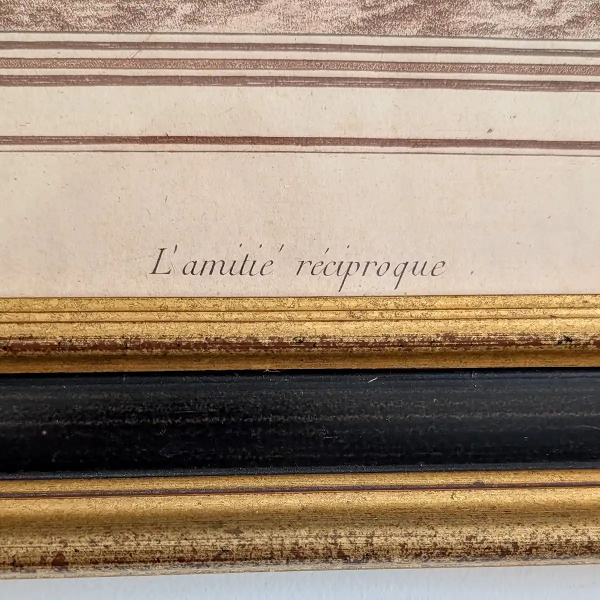 Gros plan sur le titre imprimé L’Amitié réciproque, au bas de la gravure.