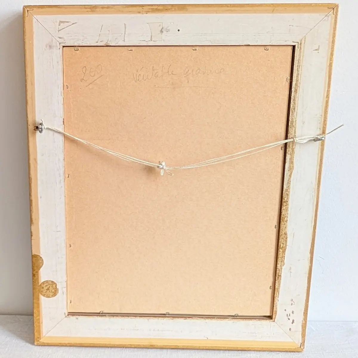 Revers du cadre avec panneau de fermeture, fil de suspension et ancienne annotation manuscrite.