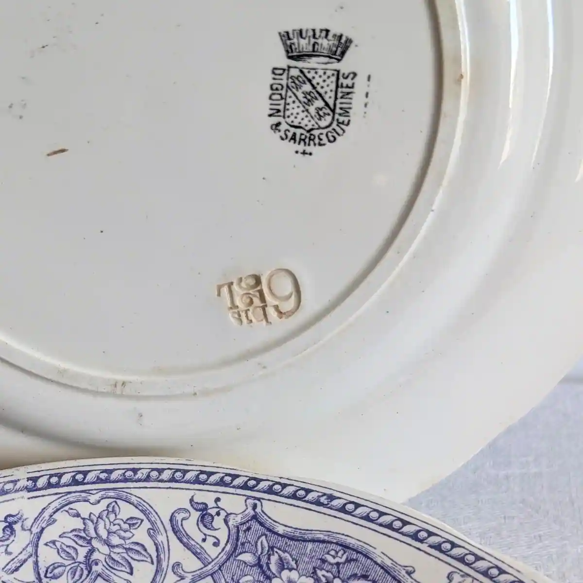 Marque couronnée Digoin et Sarreguemines imprimée au revers d'une assiette ancienne en faïence, avec numéro moulé.