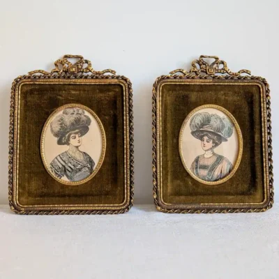 Vue frontale de la paire de cadres anciens en velours vert avec portraits de mode Belle Epoque