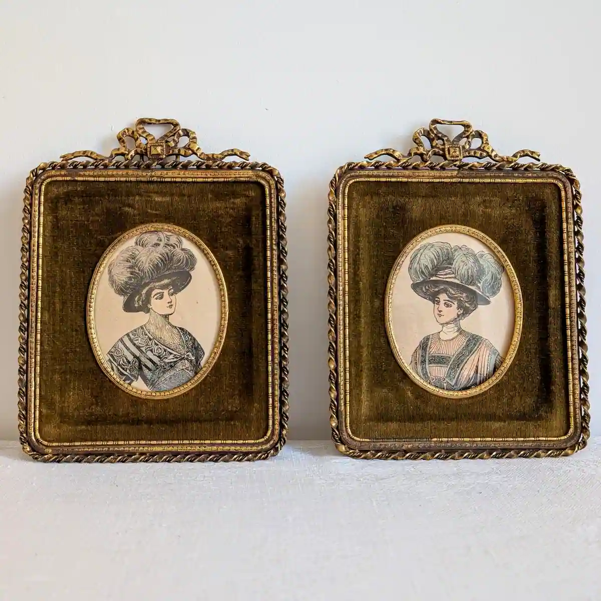 Vue frontale de la paire de cadres anciens en velours vert avec portraits de mode Belle Epoque