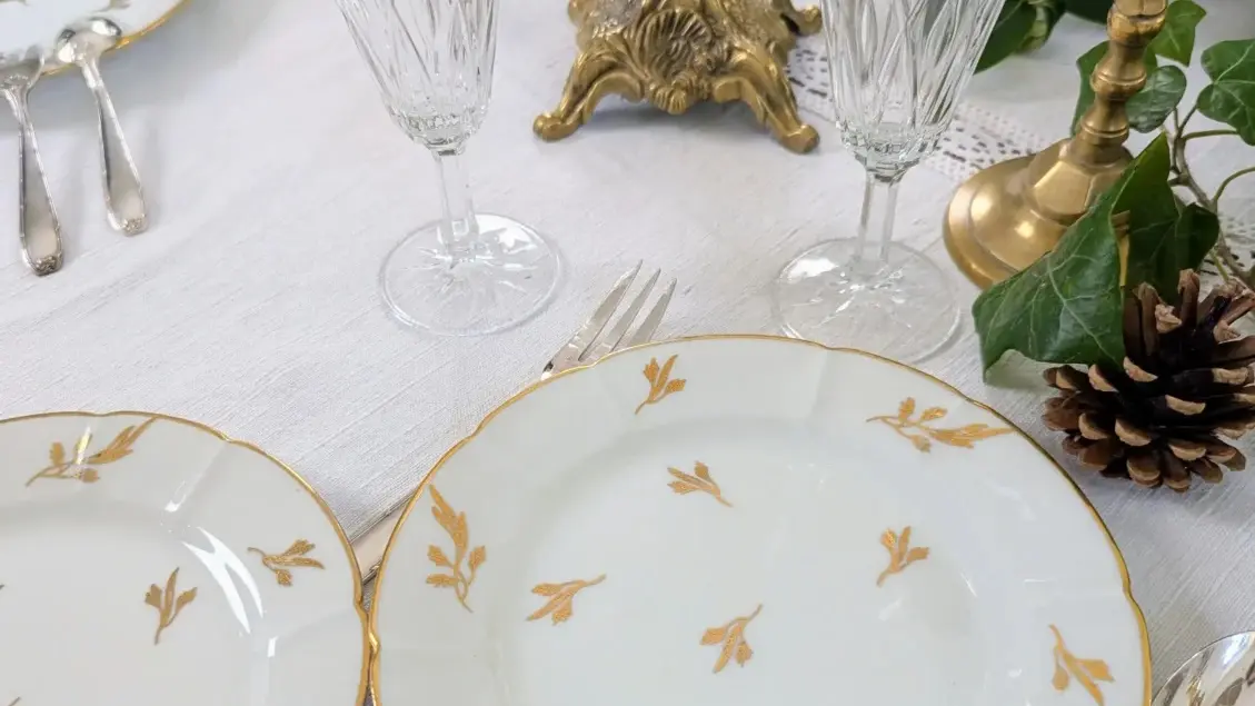 Assiettes en porcelaine ancienne dorée sur une table dressée