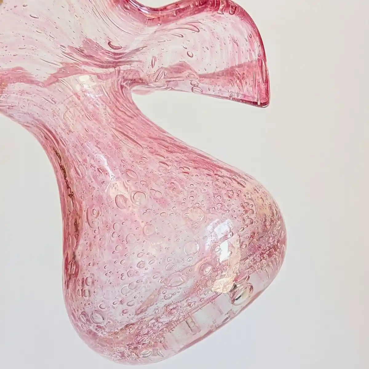 Gros plan sur la panse et la signature gravée Riom sous la base du vase en verre rose