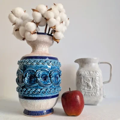 Vase en céramique vintage posé sur une table aux côtés d'un pichet et d'une pomme