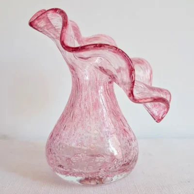 Profil d'un vase en verre soufflé rose avec corolle ondulée modelée à chaud