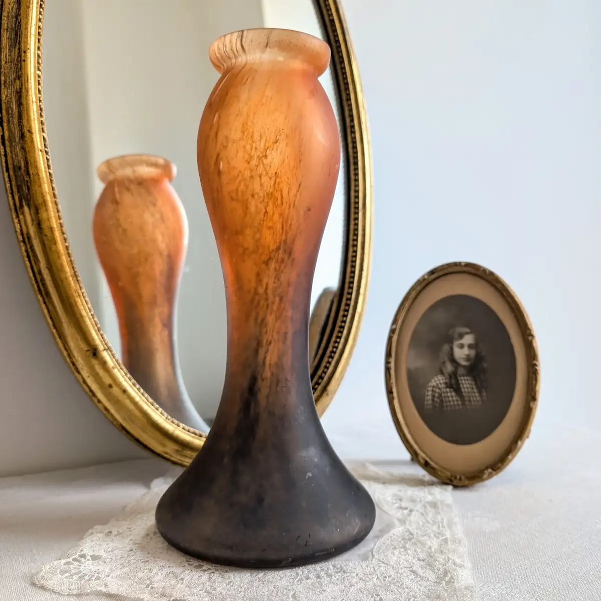 Vase Vianne en verre orangé devant un miroir ancien